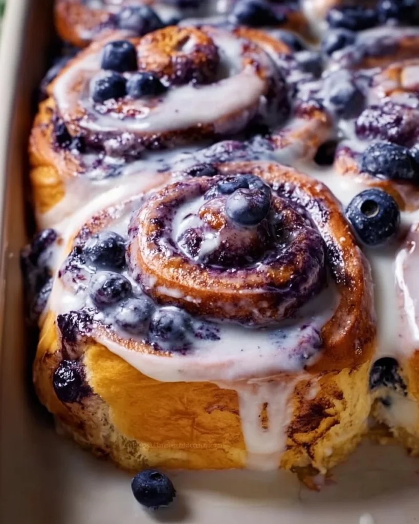 Freshly baked blueberry cinnamon rolls with icing on top