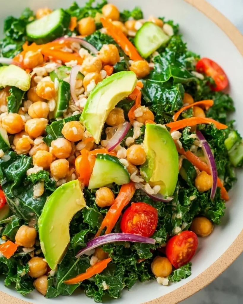 A vibrant Kale Chickpea Salad topped with Lemon Tahini Dressing.
