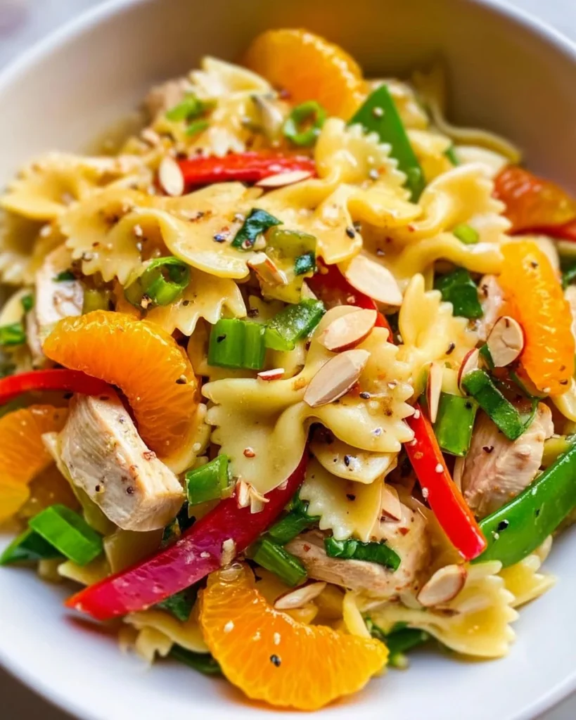 A colorful bowl of Mandarin Chicken Pasta Salad with vibrant ingredients.