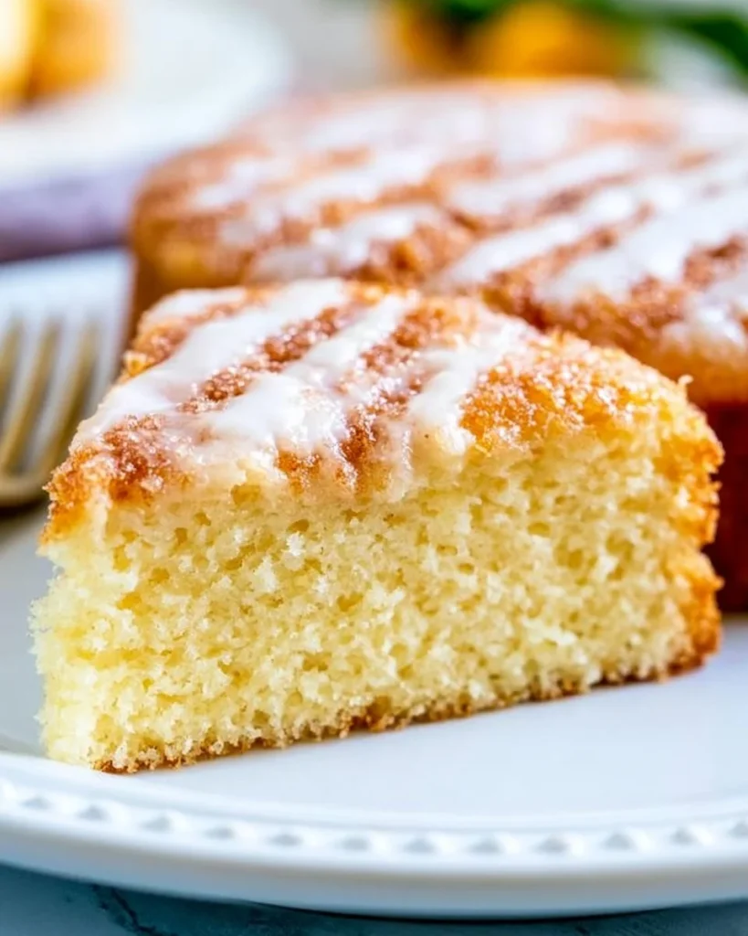 Slice of Greek Yogurt Coffee Cake on a plate with a cup of coffee